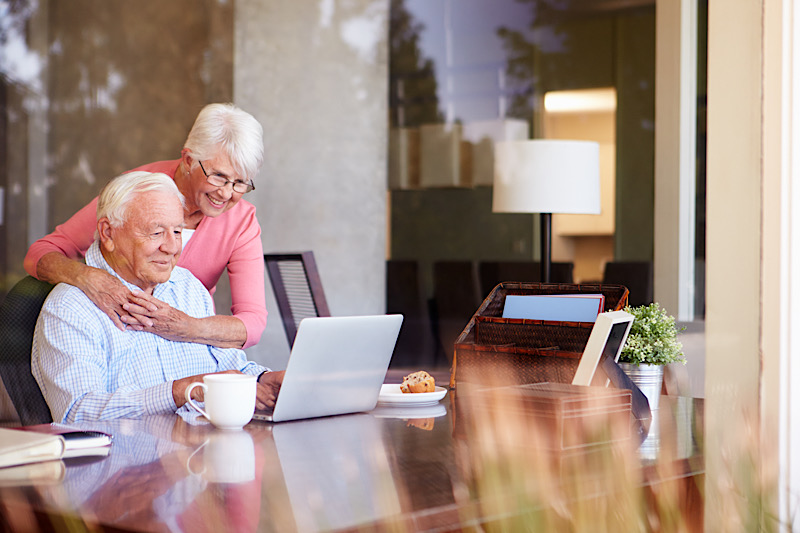 Ein älteres Ehepaar lernt eine Sprache am Laptop