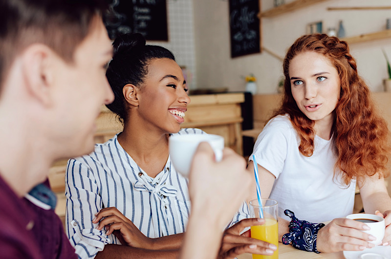Freunde treffen sich zum fortgeschrittenen Tandemgespräch in einem Cafe
